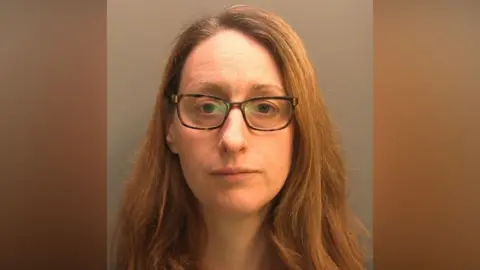 Police custody image of Fiona Phippen. She has long brown hair and is wearing spectacles. She is looking directly at the camera.