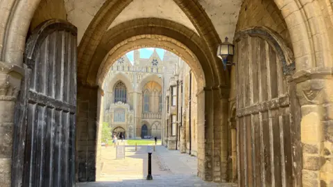 Shariqua Ahmed/BBC A picture of the Cathedral. as seen through the arches near the wooden gate.
