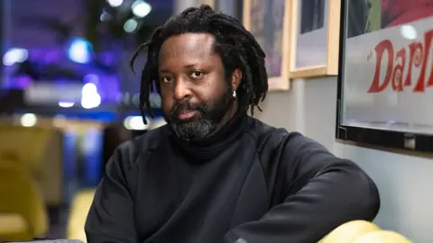 Getty Images Marlon James during the BFI Presents Get Millie Black TV preview at BFI Southbank on February 18, 2025 in London, England. has a beard and is wearing a black sweater.