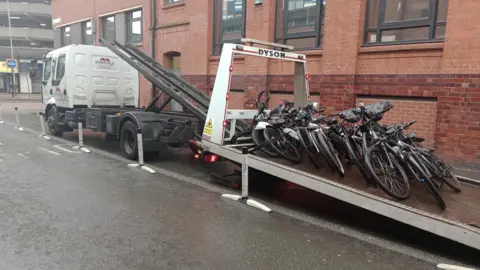 A recovery lorry with more than a dozen seized bikes on the back of it