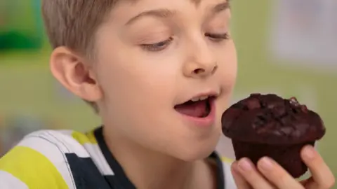 Getty Images Boys eating a chocolate muffin