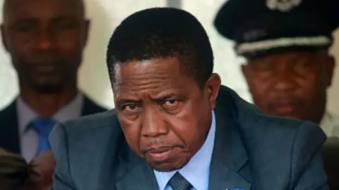 A close-up of Edgar Lungu wearing a blue suit and a tie 