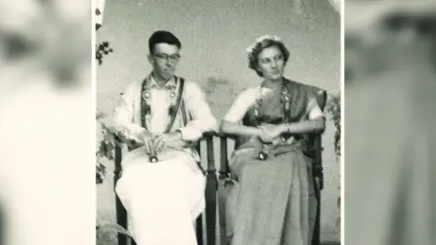 Family handout Mary, on the right, during her wedding to Philip, who is on the left. The pair married in India and Mary is wearing a sari and a flower garland in her hair.