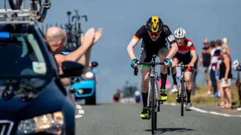 Getty Images A rider cheered on by his support vehicle staff