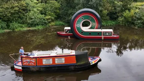 Owen Humphreys/PA A canal boat passes the looping structure on the Sheffield and Tinsley Canal