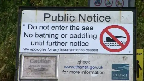 A sign warning people "Do not enter the sea, no bathing or paddling until further notice."