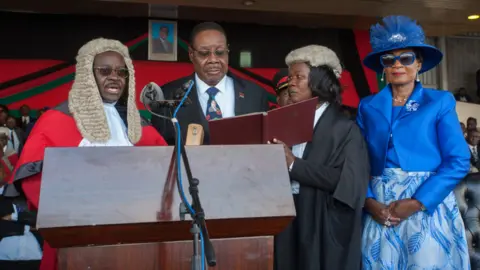 Getty Images Malawi's President elect Arthur Peter Mutharika is sworn in for his second term by Chief Justice Andrew Nyirenda (L) and Registrar of the high Court and Supreme Court Of appeal (2R) as First Lady Gertrude Mutharika looks on
