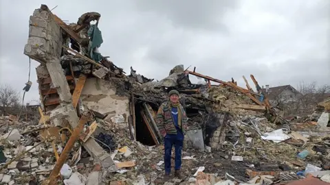 Getty Images Man outside destroyed building