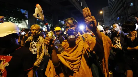 EPA A monk wearing a gas masks flashes the three singer salute walk among pro-democracy protesters