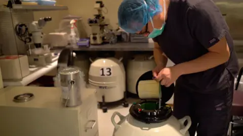 BBC Chinese A laboratory technician places tubes of human eggs into a storage tank