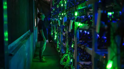 Getty Images Man staring at CPUs in Chinese bitcoin mine.