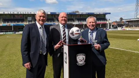 Paul Walker, Chief Executive Herefordshire Council, Chris Ammonds, Chairman Hereford FC and Councillor Harry Bramer at Edgar Street Stadium