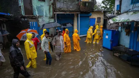 Hindustan Times through the rescue officials of Getty Images, which wear yellow raincoats, accompany residents from their homes and go out to the waterproof streets in the Kurla region in the Mumbai region. 