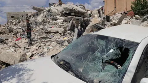 EPA Palestinians inspect a destroyed building in Kafr Dan, in the occupied West Bank (4 September 2024)