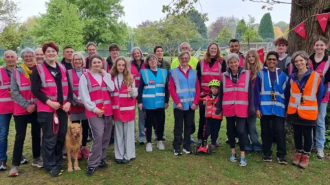 Stroud Park Run A large group of park run volunteers in Stroud line up for the camera. They are a mixture of ages and genders and are all wearing brightly coloured tabards