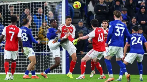William Saliba challenges Thierno Barry for the ball