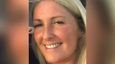 Joanne's Flowers Close up of Joanne Walsh who has long blond hair and is wearing a gold earrings. She is smiling.