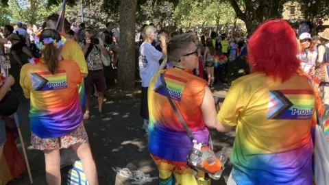 People in t-shirts which say Proud on the back.