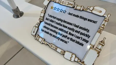 Nicola Haseler/BBC A framed quotation which reads "I started vaping because I had anxiety, but didn't realise how easily and quickly I would become addicted. Now I can't stop – always needing that puff or that inhale has made my anxiety worse."