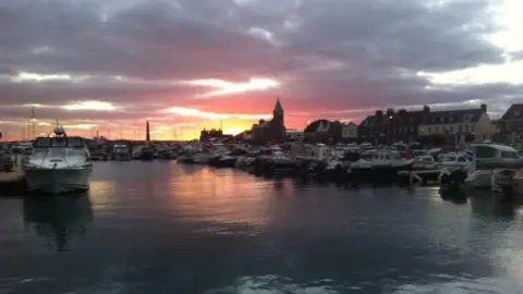 BBC news sunset over a harbour