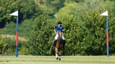 Getty Images A picture of the Prince of Wales on horseback playing polo, with two posts either side of him.