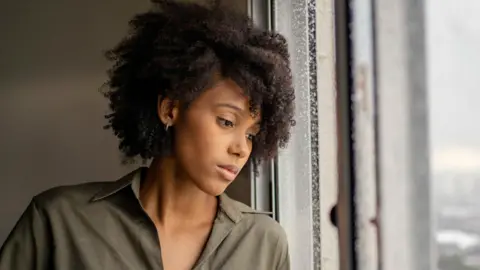 A woman looking out of a window. 