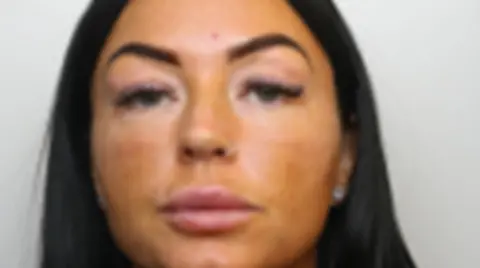 Avon and Somerset Police A close-up custody photo of a woman with black hair and dark eyebrows