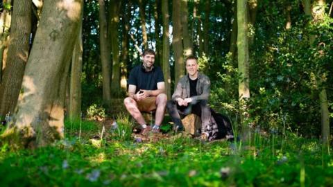 Two men sitting in wood