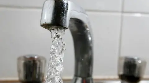 Getty Images A silver tap pouring out water