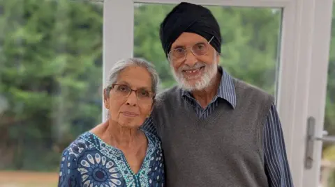 Sardul Gill stood with his wife  Inderjit Gill