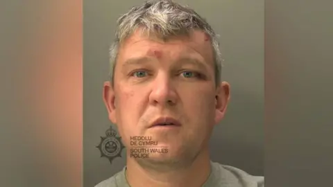 South Wales Police A mugshot of a man with grey hair looking at the camera