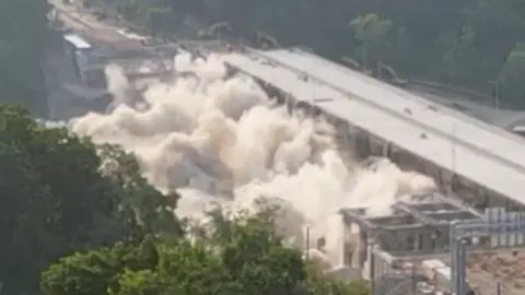 Clouds of smoke are seen after a controlled demolition.