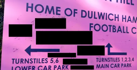 Met Police A pink Dulwich Hamlet FC sign with black blocks showing where offensive comments had been written