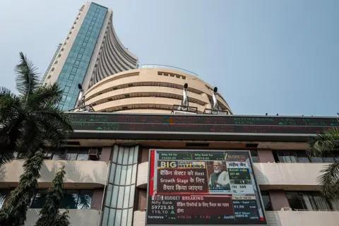 AFP via Getty Images A digital screen displays a broadcast of the budget speech by Indian Finance Minister Nirmala Sitharaman (unseen) as Prime Minister Narendra Modi (R on screen) gestures. 