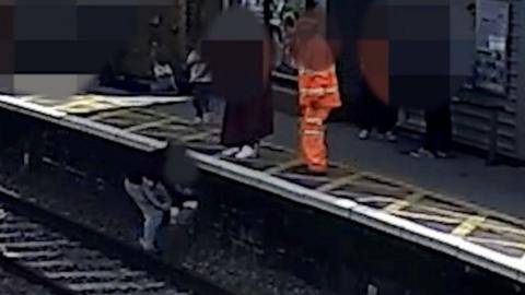 CCTV still of the rescue of a boy who fell on to tracks 