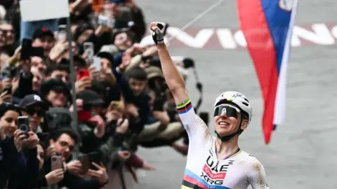 Tadej Pogacar celebrates winning the 2026 Strade Bianche