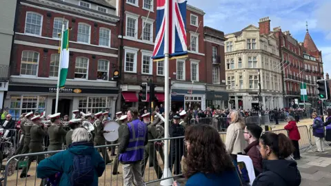 People gathered to watch a marching band walk through Windsor.