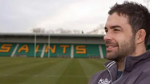 Budge Pountney with dark hair and beard at the Saints ground