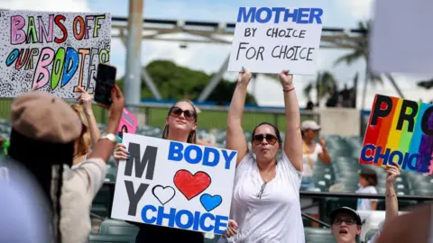 Getty Images Abortion rights supporters rally in Miami, Florida in September in support of Amendment 4. They hold signs that read "My Body, My Choice" and "Mother For Choice, By Choice."