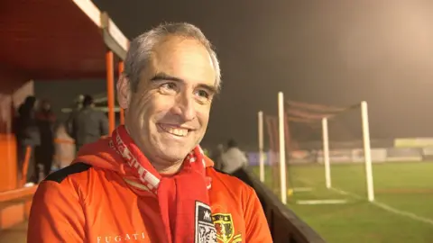 Fan Neil Cornelius wearing his Sittingbourne shirt and scarf