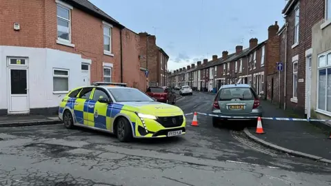 Cordon at the end of a street in Derby blocked by police car