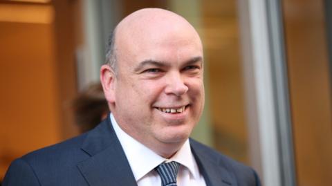 British businessman Mike Lynch in blue suit, blue tie and white shirt smiling 