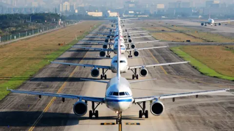 Getty Images A number of aeroplanes lined up in an airport