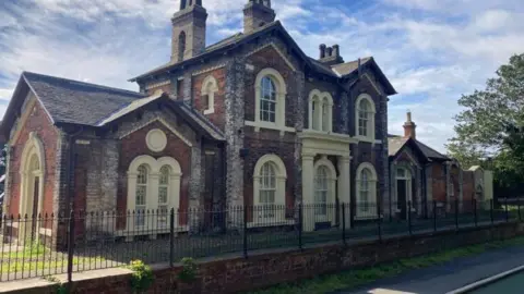 Hull City Council A brown and buff coloured, brick built station building. The platform is retained. 