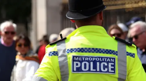 A police officer stands in front of blurred people in London on 28 May 2025.