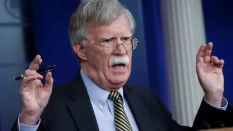 Reuters John Bolton raises his hands in the air as he speaks from a podium