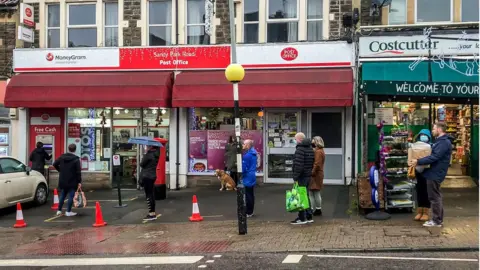 PA Media People queue for a post office on Sandy park Road, Bristol