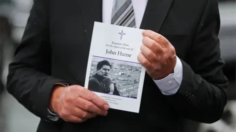 PA Media A mourner holds the order of service for the funeral Mass.