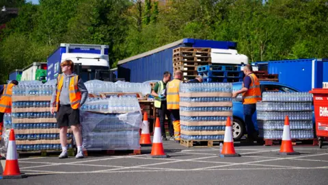 PA Media People collecting bottled water at Broadsands Car Park in Paignton