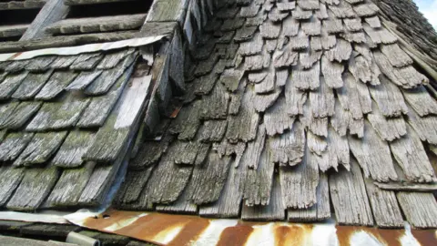 John Fosker Wooden shingles on a roof that have deterioated.
